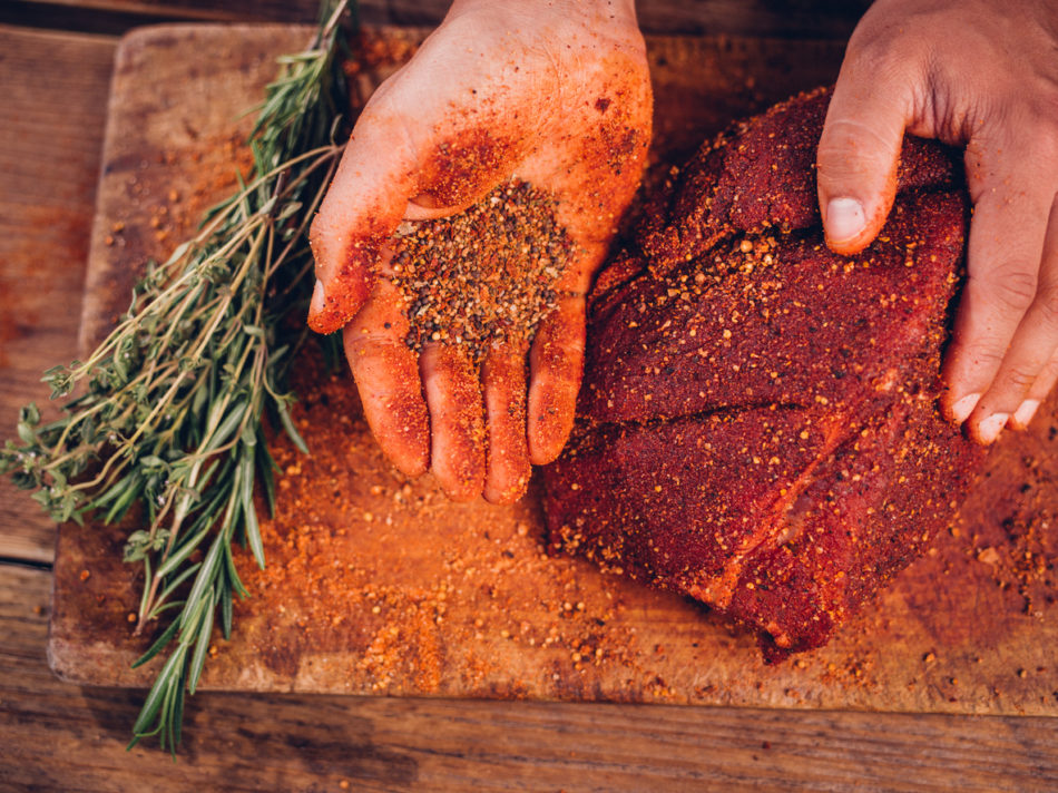 Hand rubbing a spice rub on meat